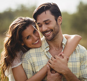 Young couple smiling and embracing outdoors