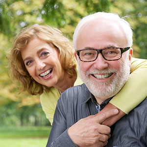 Middle-aged couple smiling and hugging outdoors
